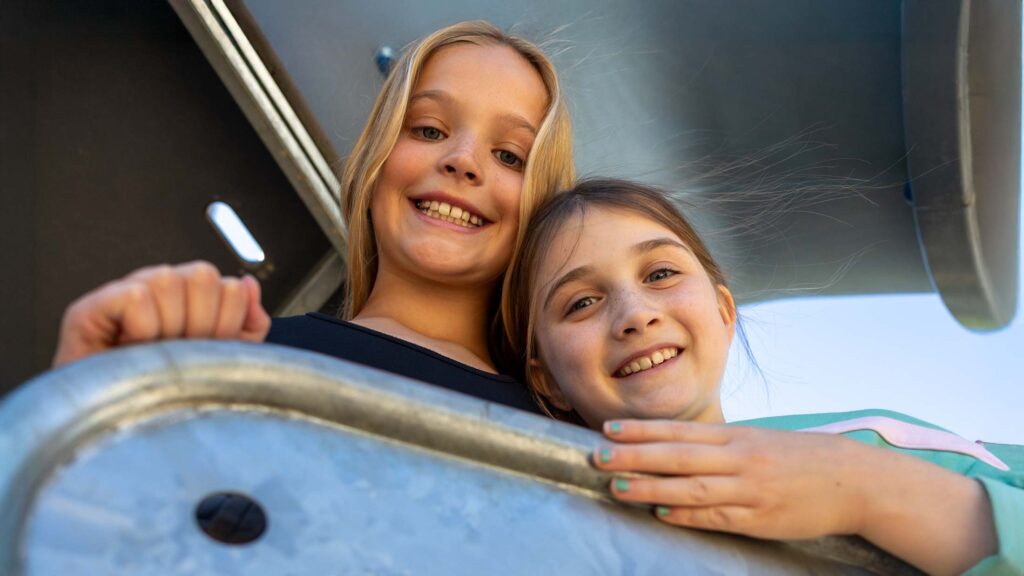 Two Calgary Academy students smile while playing on one of the school's playgrounds.